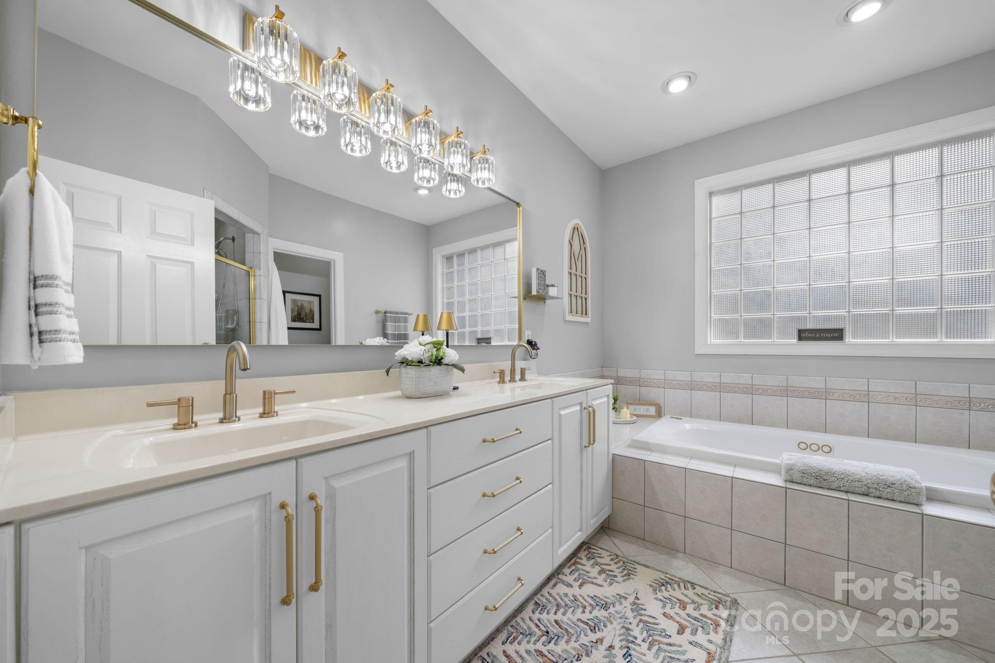 104 Blackhawk Ridge Court Granite Falls, NC 28630 - Photo 22 of 48 a spacious bathroom with a double vanity sink large mirror and a bathtub