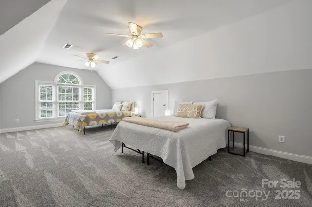 a spacious bedroom with a bed and a chandelier