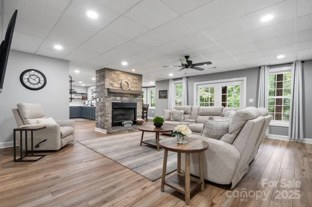 a living room with furniture a fireplace and a large window