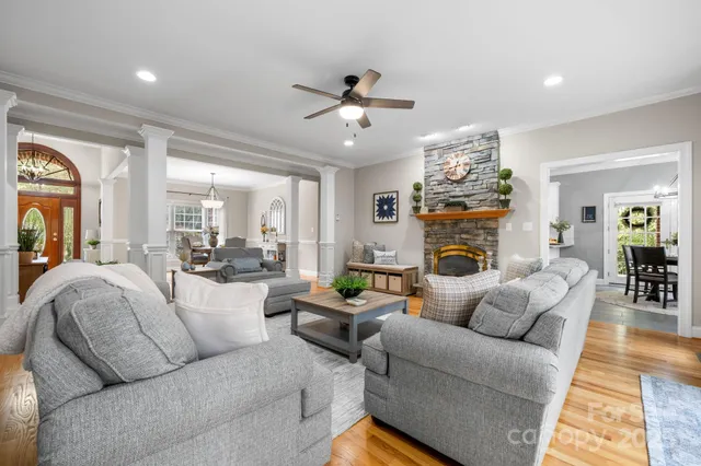 a living room with furniture a fireplace and a chandelier