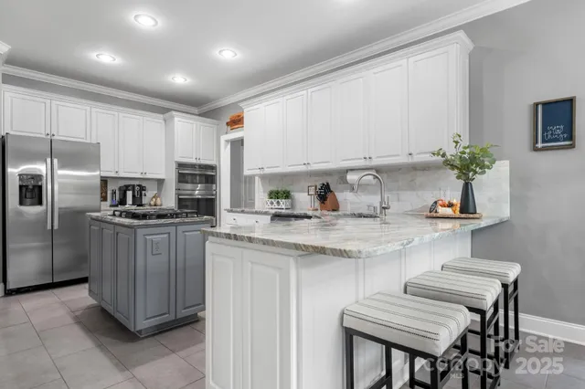 a kitchen with kitchen island granite countertop a sink and refrigerator