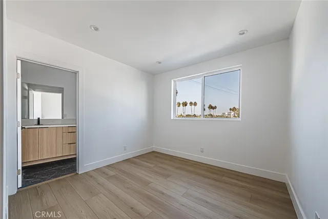 a view of an empty room with closet and a window