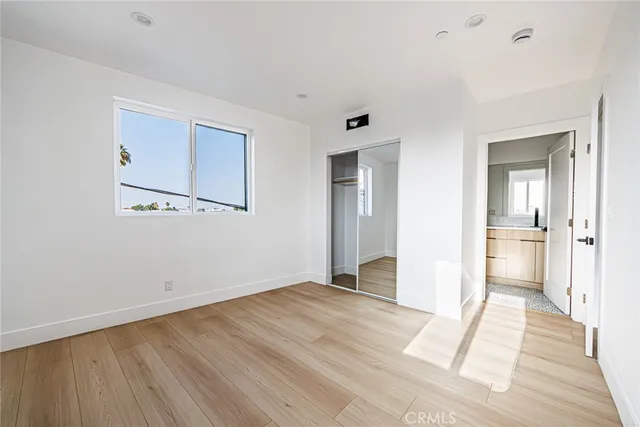 a view of a room with wooden floor and a bathroom