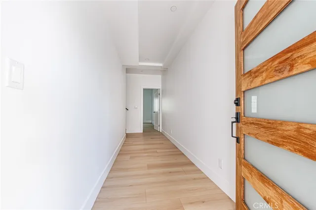 a view of a hallway with wooden floor and staircase