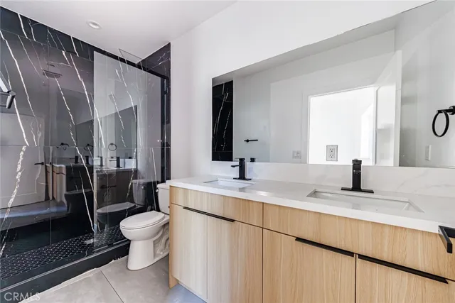 a bathroom with a granite countertop sink toilet and shower