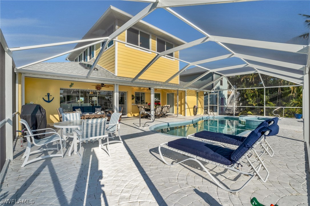 3278 York Road St. James City, FL 33956 - Photo 11 of 49 a view of a patio with a dining table and chairs with wooden floor