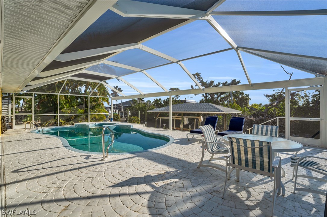3278 York Road St. James City, FL 33956 - Photo 13 of 49 a view of a patio with a table and chairs under an umbrella