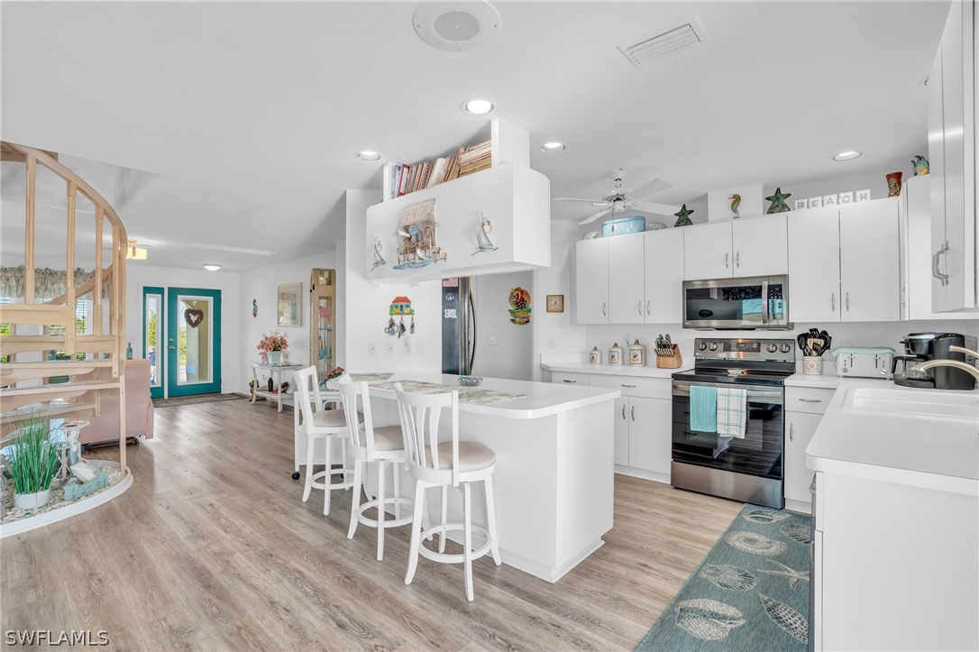 3278 York Road St. James City, FL 33956 - Photo 22 of 49 a large white kitchen with stainless steel appliances