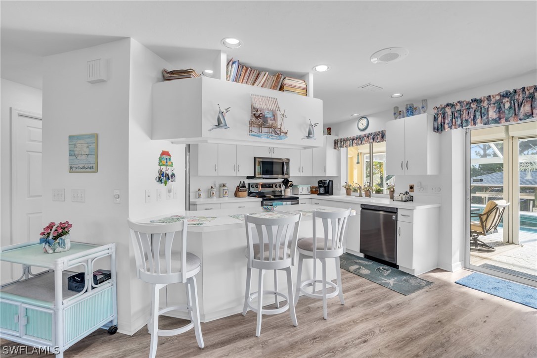 3278 York Road St. James City, FL 33956 - Photo 23 of 49 a kitchen with stainless steel appliances kitchen island granite countertop a table and chairs in it