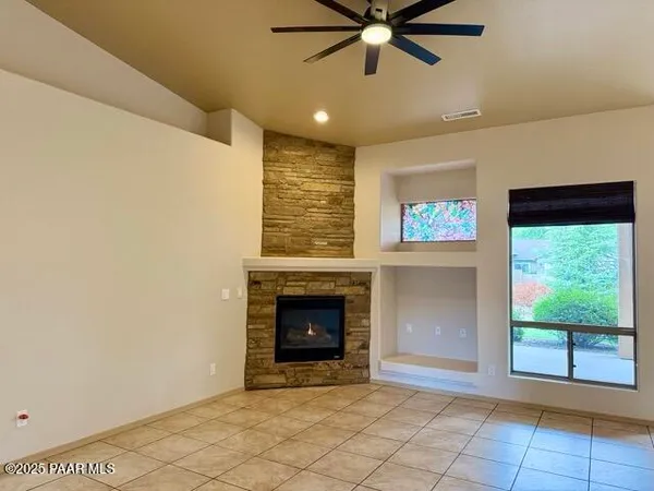 a view of an empty room with a fireplace and a window