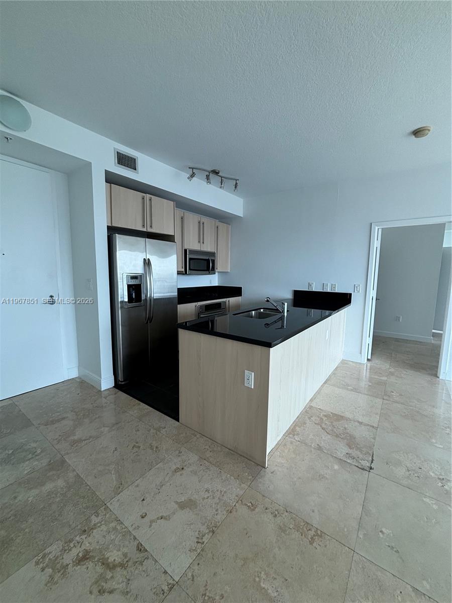 79 Southwest 12th Street, Unit 2703S Miami, FL 33130 - Photo 11 of 61 a kitchen with stainless steel appliances a refrigerator a stove a sink a microwave and cabinets