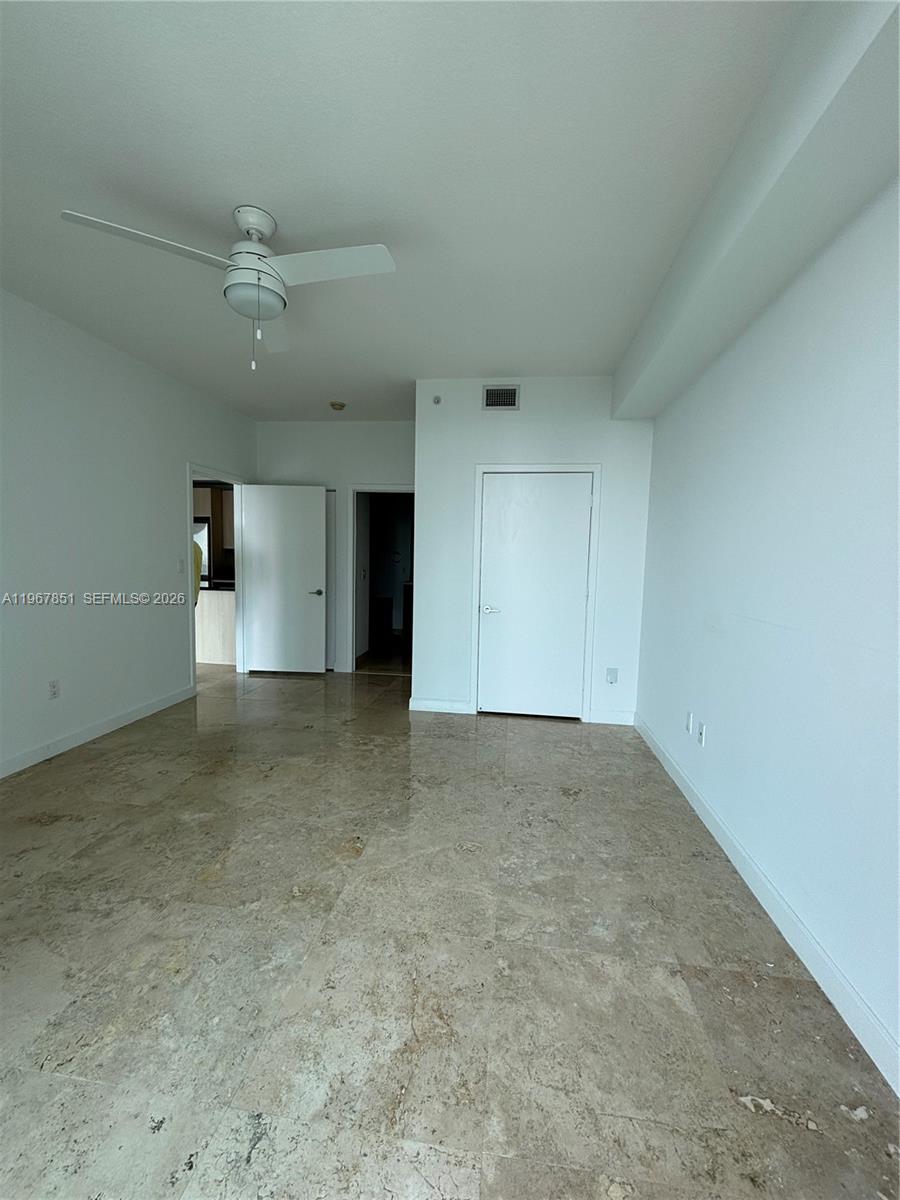 79 Southwest 12th Street, Unit 2703S Miami, FL 33130 - Photo 16 of 61 an empty room with a empty space and a ceiling fan