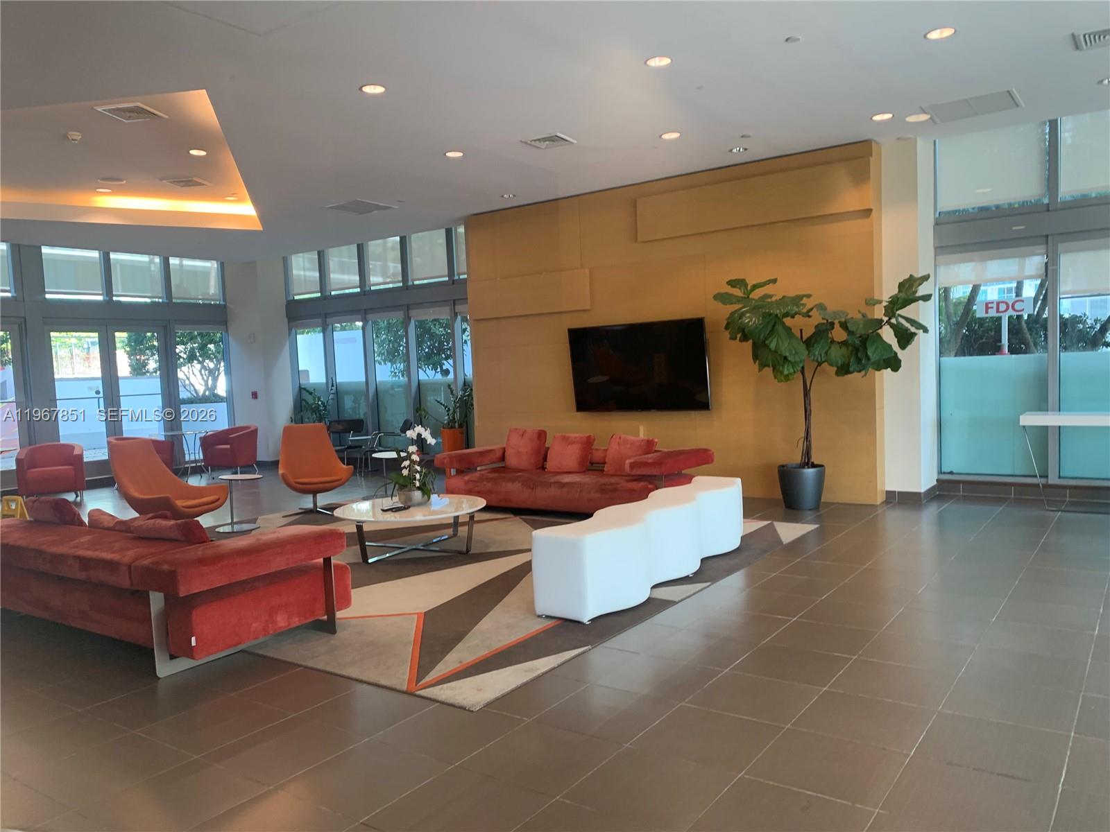 79 Southwest 12th Street, Unit 2703S Miami, FL 33130 - Photo 46 of 61 a living room with fireplace furniture and a flat screen tv