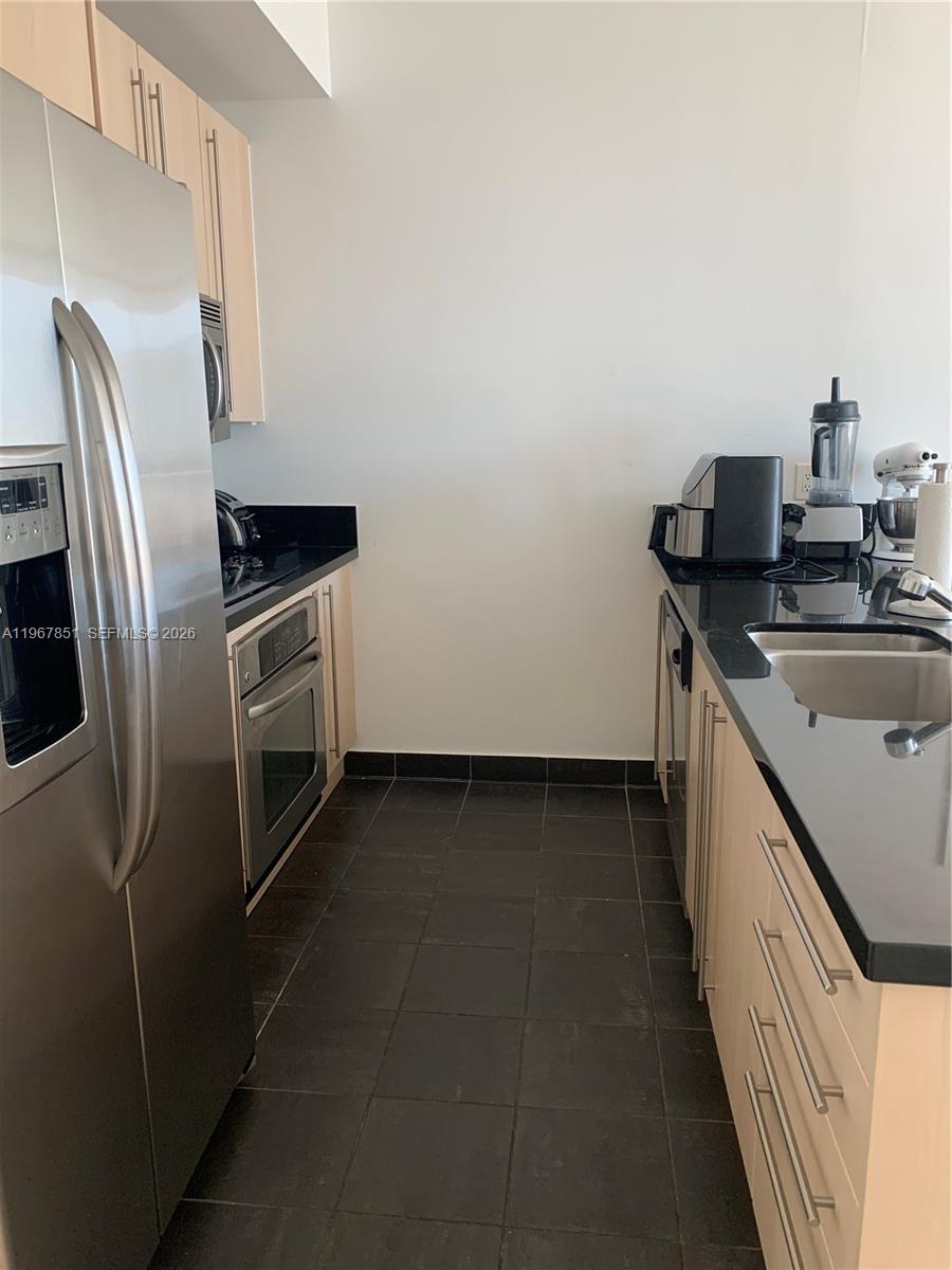79 Southwest 12th Street, Unit 2703S Miami, FL 33130 - Photo 10 of 61 a kitchen with a sink and stainless steel appliances