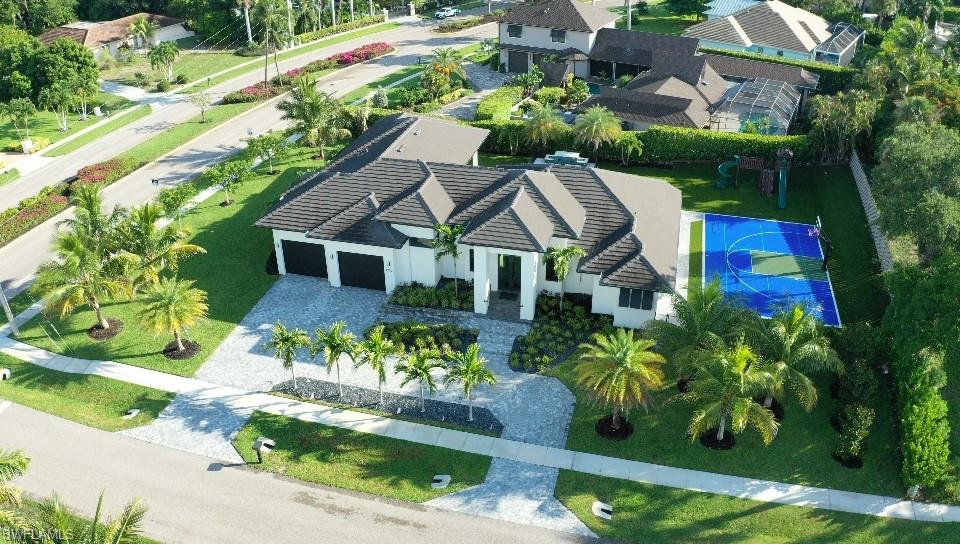 1702 Ludlow Road Marco Island, FL 34145 - Photo 6 of 47 Modern single-story residence with a multi-car garage, extensive paver driveway, and a private sports court