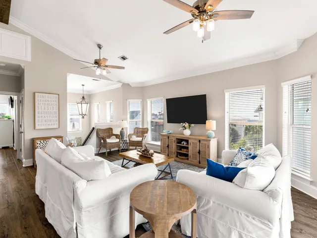 a living room with furniture a flat screen tv and a large window