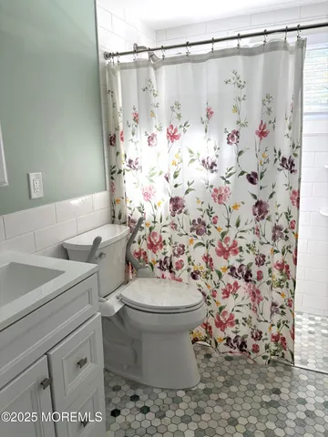 a bathroom with a sink a toilet and shower curtain