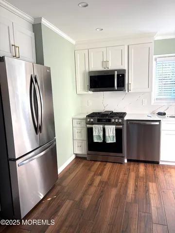 a kitchen with stainless steel appliances granite countertop a refrigerator a stove a sink and a microwave