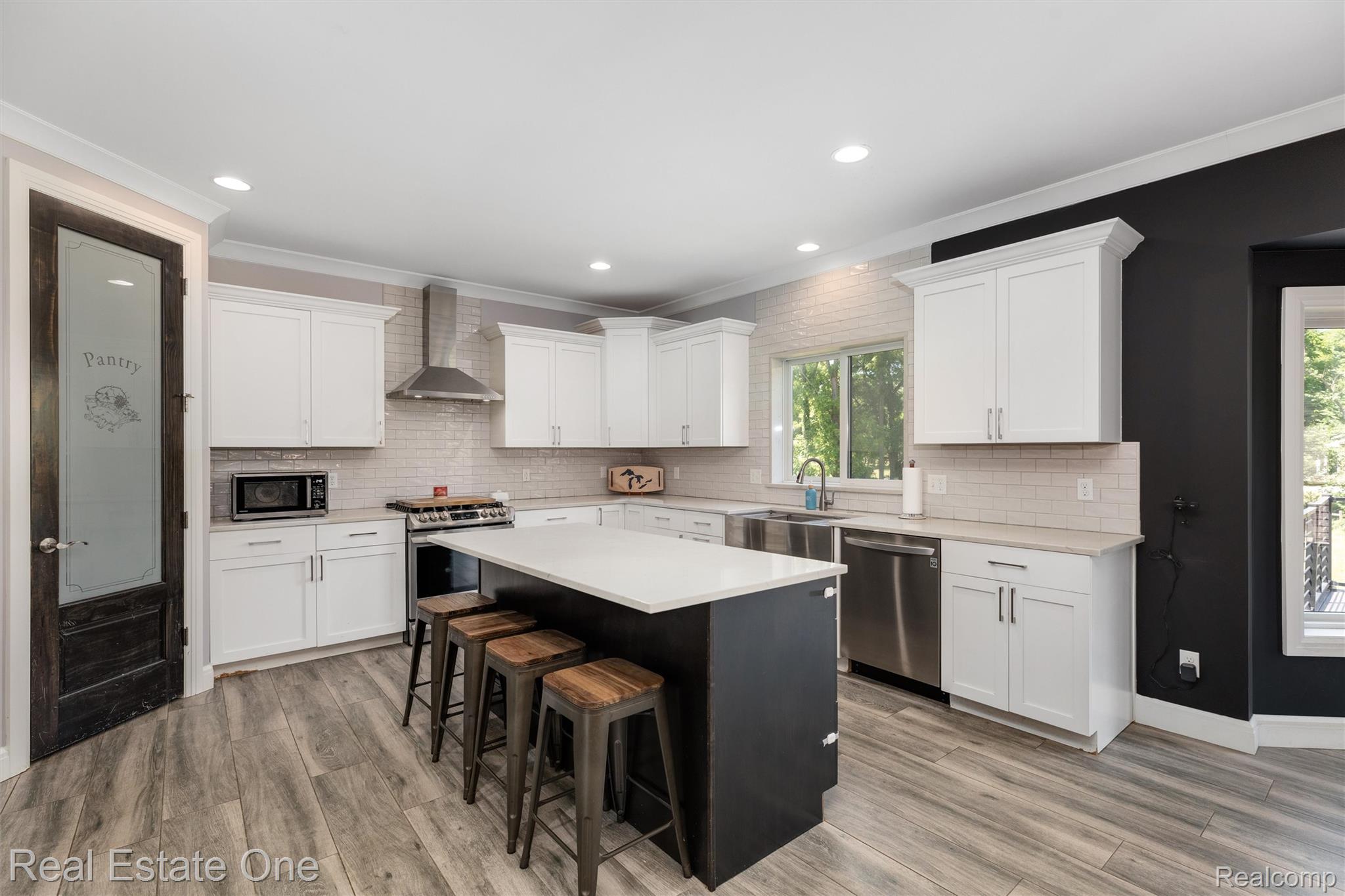 2983 28 Mile Road Washington, MI 48094 - Photo 9 of 54 Spacious kitchen featuring white cabinetry, light-colored countertops, and stainless steel appliances