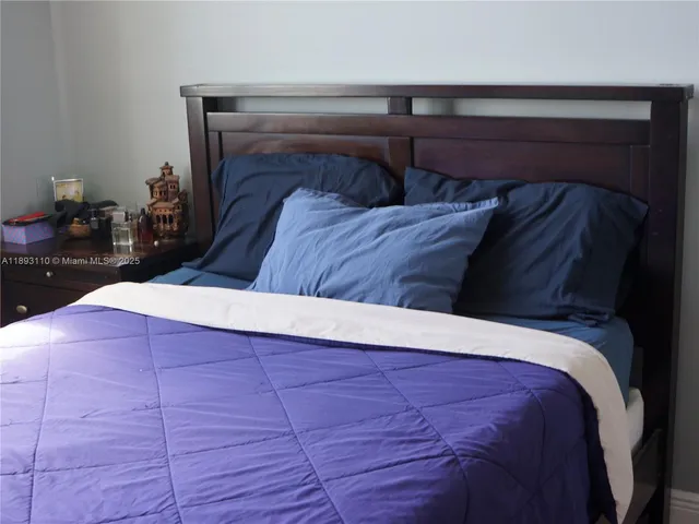a bed sitting in a bedroom and wooden floor