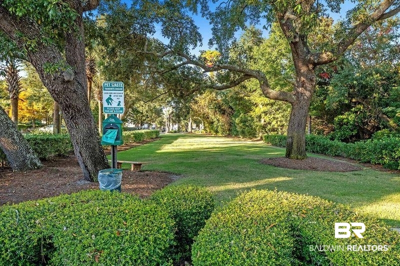 27800 Canal Road, Unit 411 Orange Beach, AL 36561 - Photo 45 of 49 Spacious green area featuring mature trees and maintained shrubbery