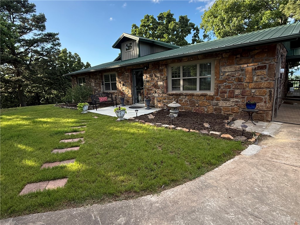 9417 Puddin Ridge Road Ozark, AR 72949 - Photo 41 of 42 Stone-clad exterior featuring a green metal roof and an upper dormer
