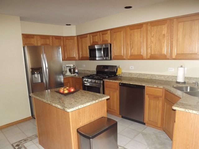 180 Grove Court, Unit 180 Lemont, IL 60439 - Photo 6 of 22 a kitchen with stainless steel appliances granite countertop a sink stove refrigerator and microwave