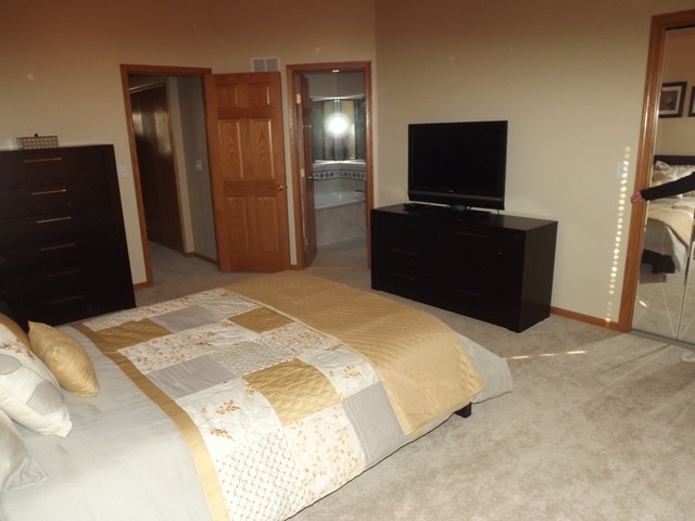 180 Grove Court, Unit 180 Lemont, IL 60439 - Photo 10 of 22 a bedroom with a bed and a flat screen tv