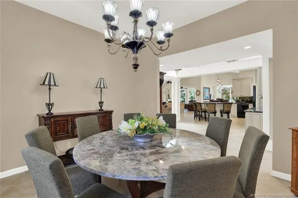 a kitchen with stainless steel appliances granite countertop a stove a sink a dining table and chairs with wooden floor