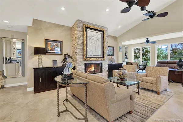 a living room with furniture a ceiling fan and a flat screen tv