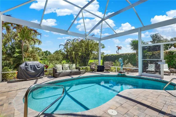 a kitchen with stainless steel appliances granite countertop a kitchen island hardwood floor sink stove dining table and chairs