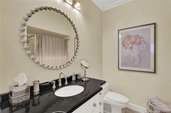 a bathroom with a granite countertop sink a toilet a mirror and shower