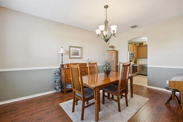 a view of a dining room with furniture a chandelier and wooden floor