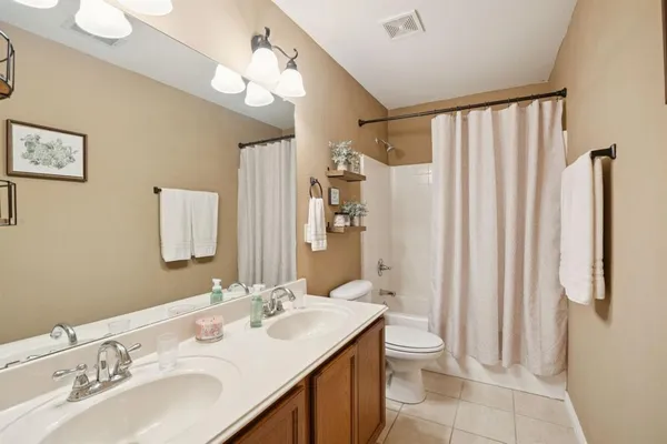 a bathroom with a double vanity sink mirror and toilet
