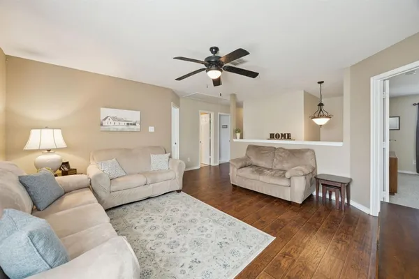 a living room with furniture and a wooden floor