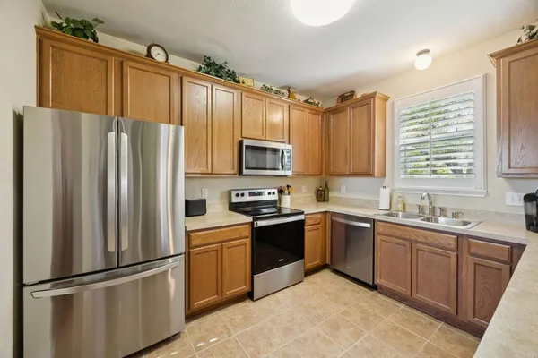 a kitchen with granite countertop stainless steel appliances a refrigerator sink and microwave