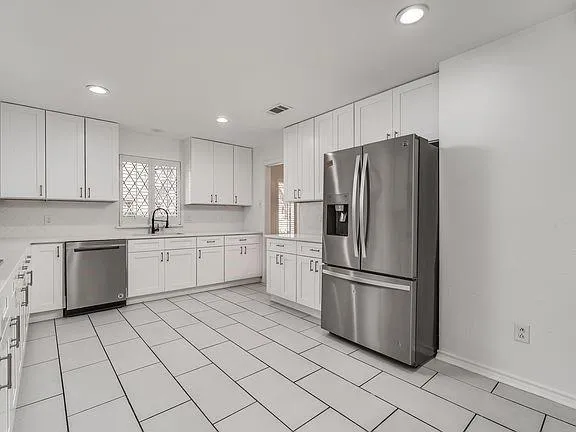 a kitchen with a refrigerator sink and cabinets