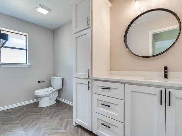 a bathroom with a toilet a sink and a mirror