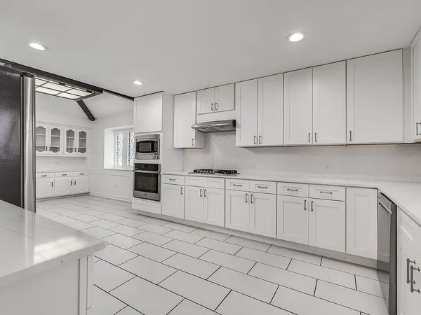 a kitchen with cabinets appliances and a sink