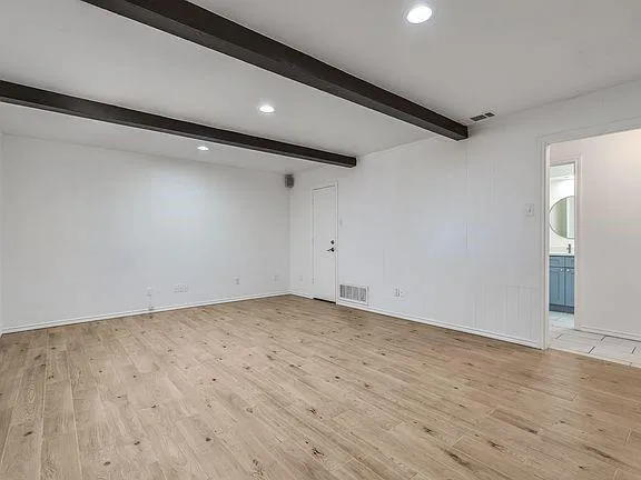 a view of empty room with wooden floor and ceiling fan