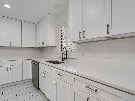a kitchen with white cabinets and a sink