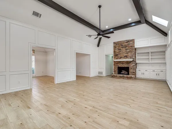 a view of empty room with wooden floor and fireplace
