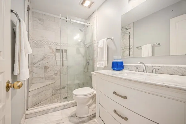 a bathroom with a sink a toilet and shower