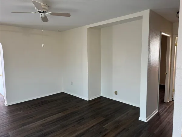 a view of an empty room with wooden floor