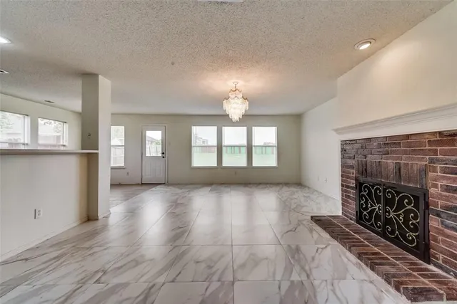 a view of an empty room with a fireplace and a window