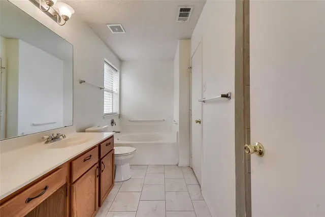 a bathroom with a double vanity sink toilet mirror and bathtub