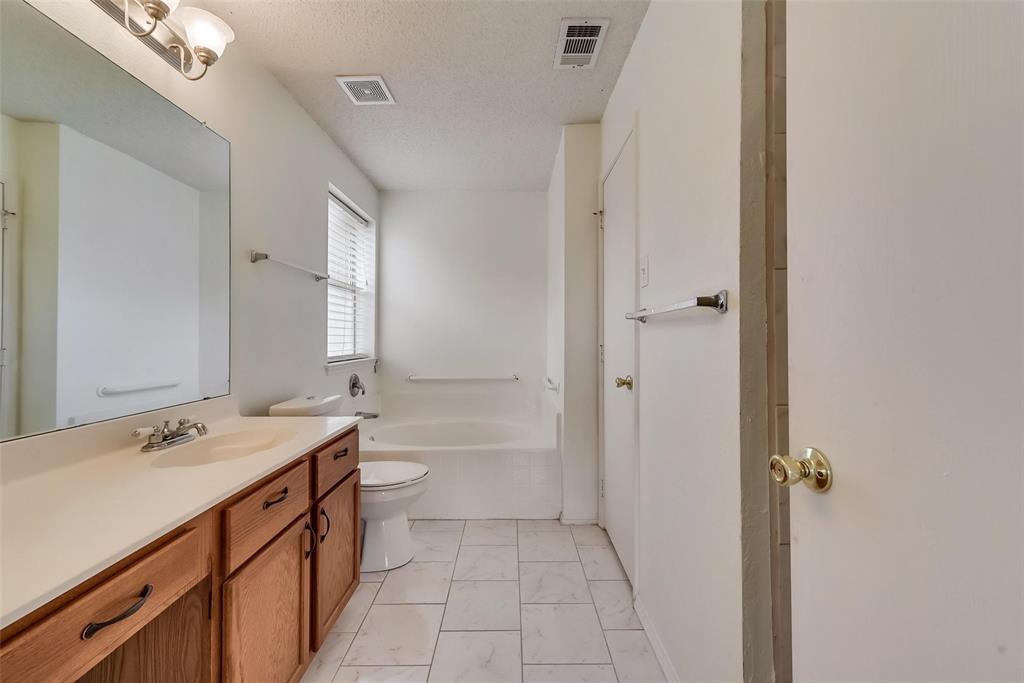 13401 Ponderosa Ranch Road Fort Worth, TX 76262 - Photo 21 of 22 a bathroom with a double vanity sink toilet mirror and bathtub