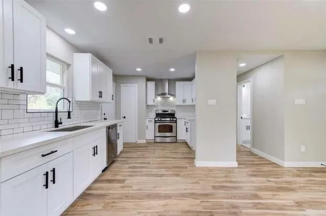 a large kitchen with stainless steel appliances granite countertop a sink and cabinets