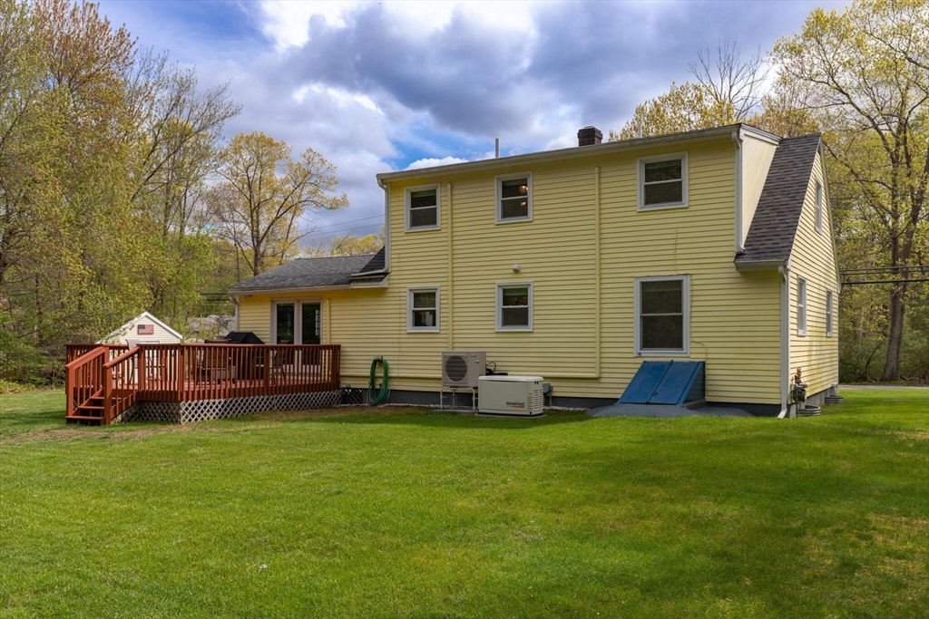 70 Parham Road Tyngsboro, MA 01879 - Photo 37 of 40 a front view of house with yard and trees in the background