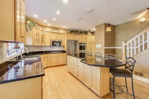a kitchen with granite countertop a sink appliances cabinets and furniture